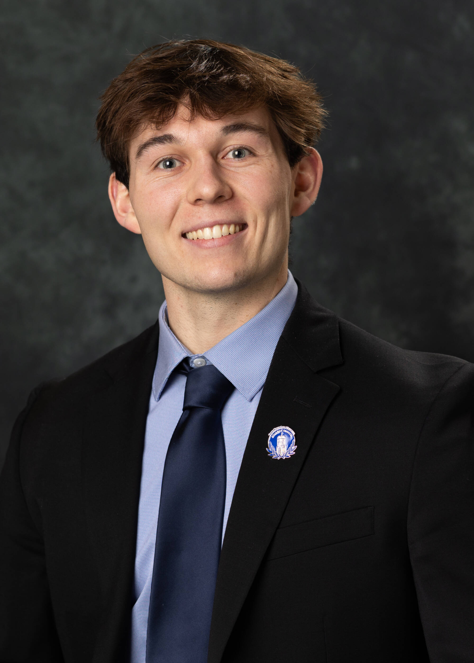 Stephen Boujoulian smiling in a suit